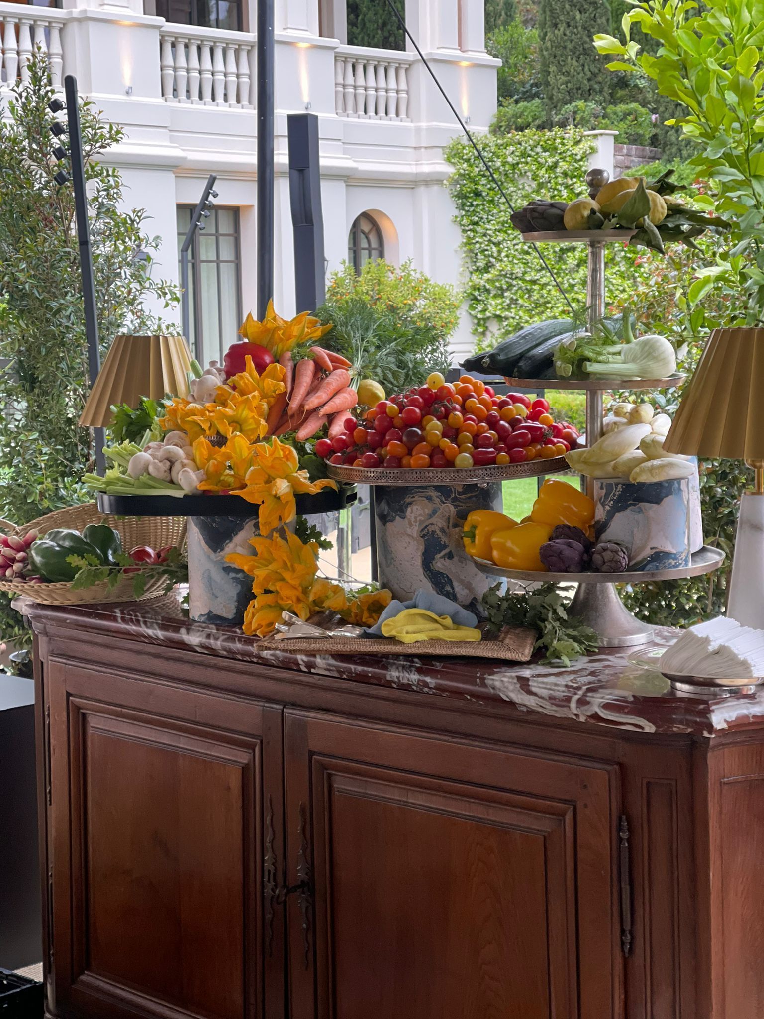 A wooden buffet table filled with fruits and vegetables.