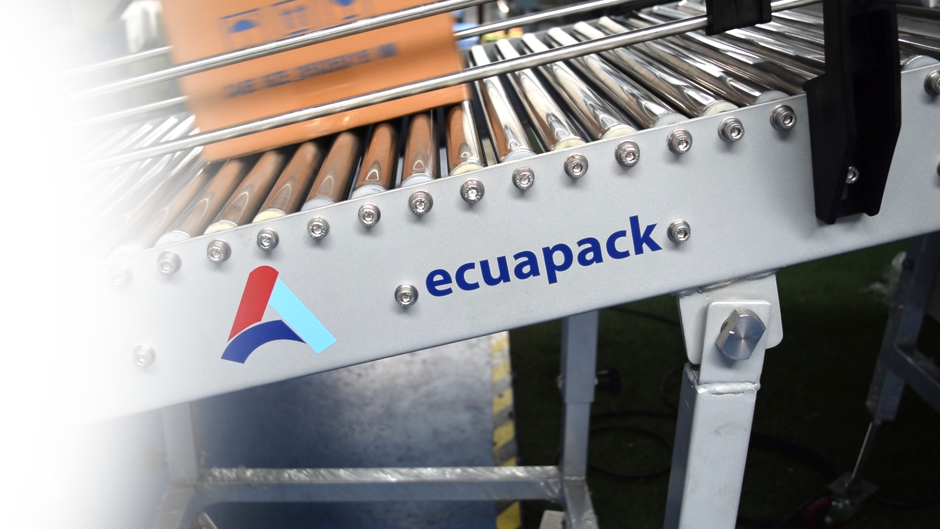 Máquina Ecuapack con filas de varillas metálicas y rodillos marrones en un entorno industrial.