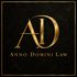 Gold “AD” monogram with “Anno Domini Law” on a black textured background, framed by a thin gold border