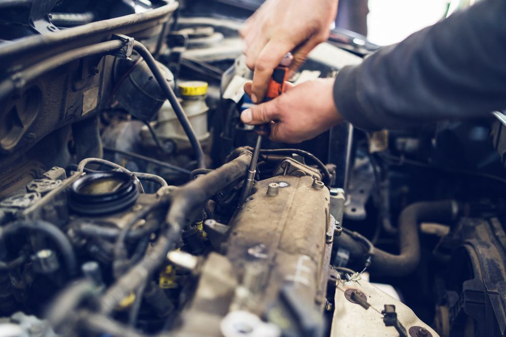 Hands Using a Screwdriver to Work on a Car Engine — Bob Kolln Automotive In Charmhaven, NSW