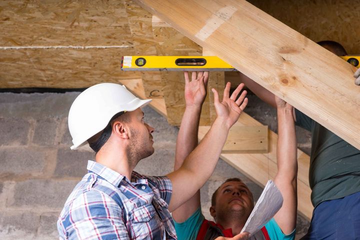 a group of construction workers are working on a wooden structure