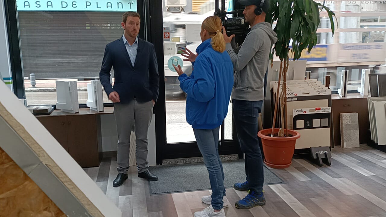 Un hombre con traje está parado junto a una mujer con una chaqueta azul.