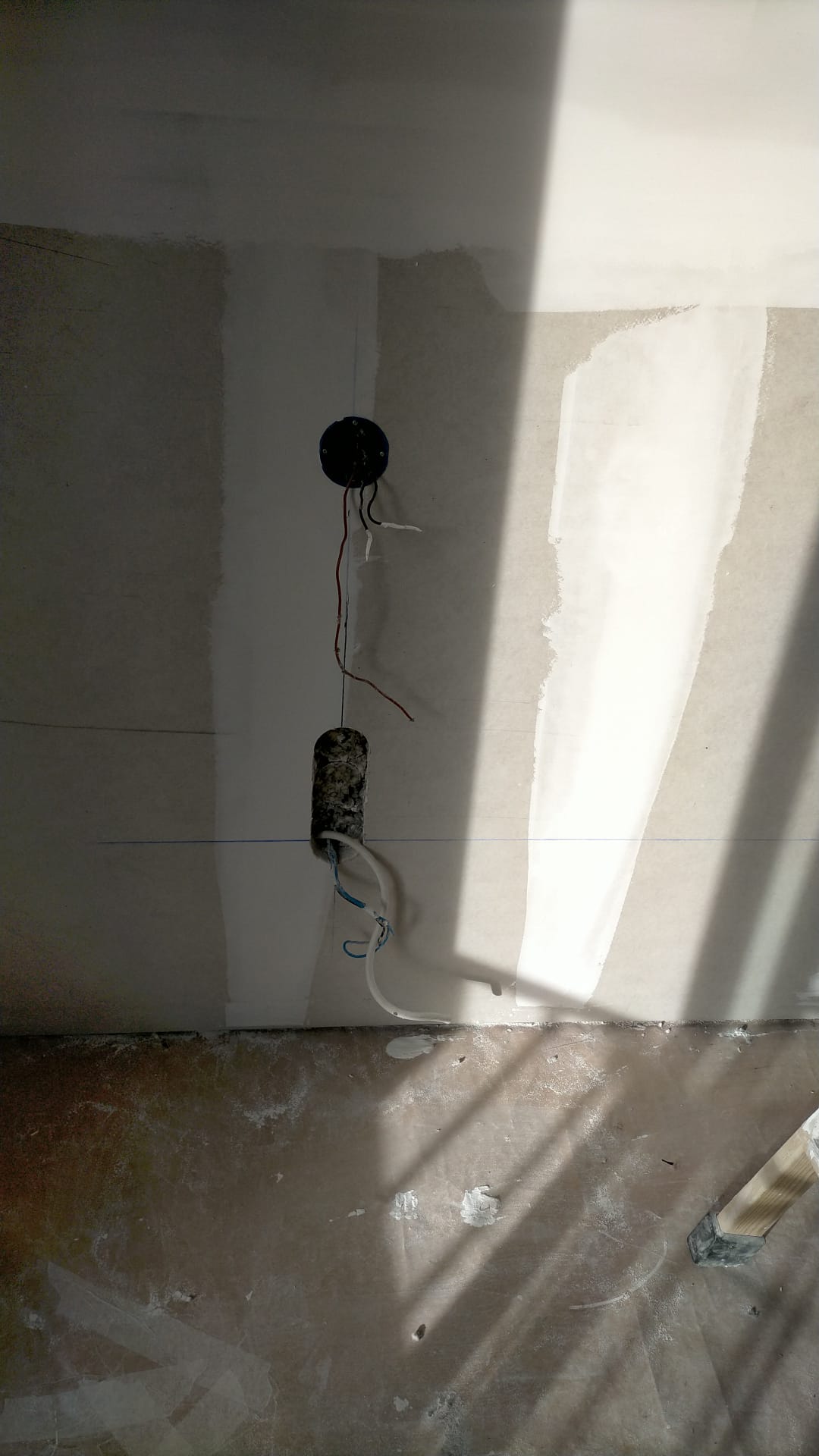 Hay un agujero en la pared del que salen cables.