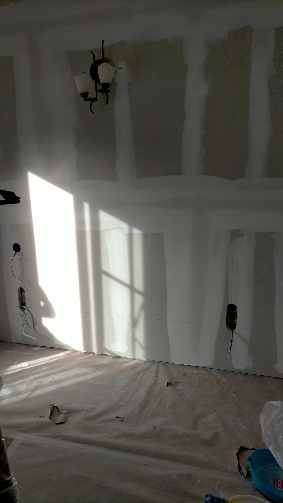 Una habitación con paredes blancas y una lámpara de araña colgando del techo.