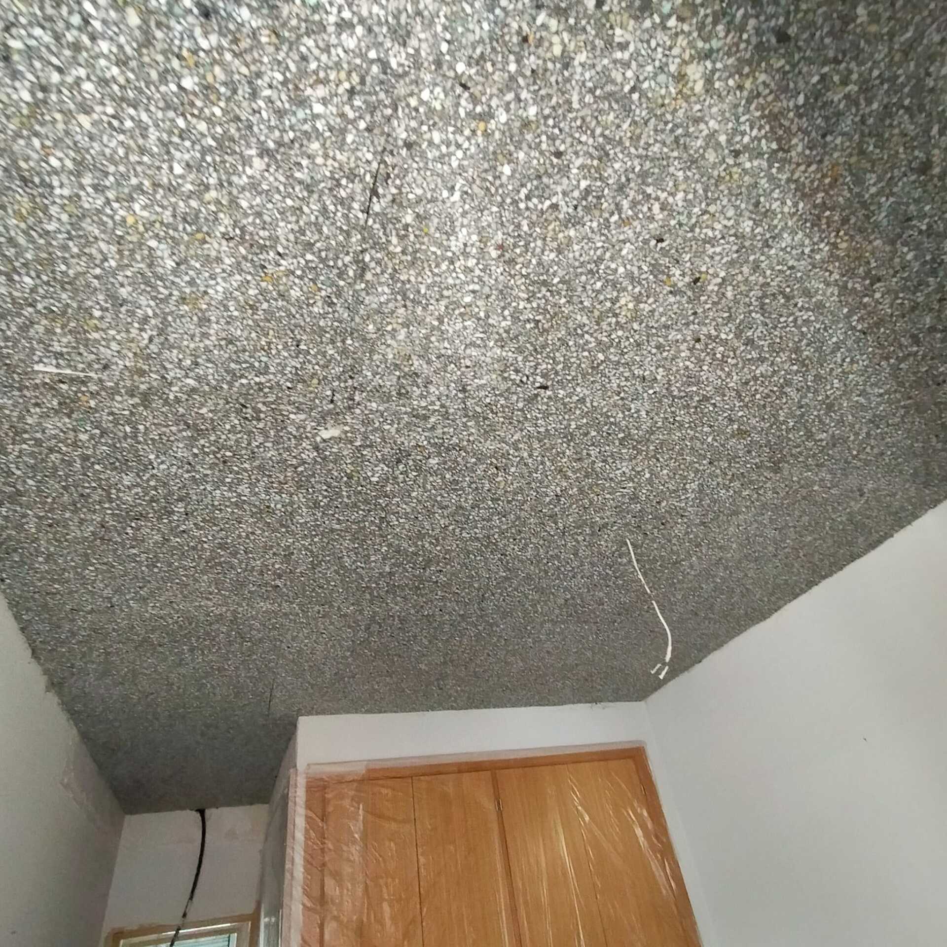 Una habitación con techo gris y puerta de madera.