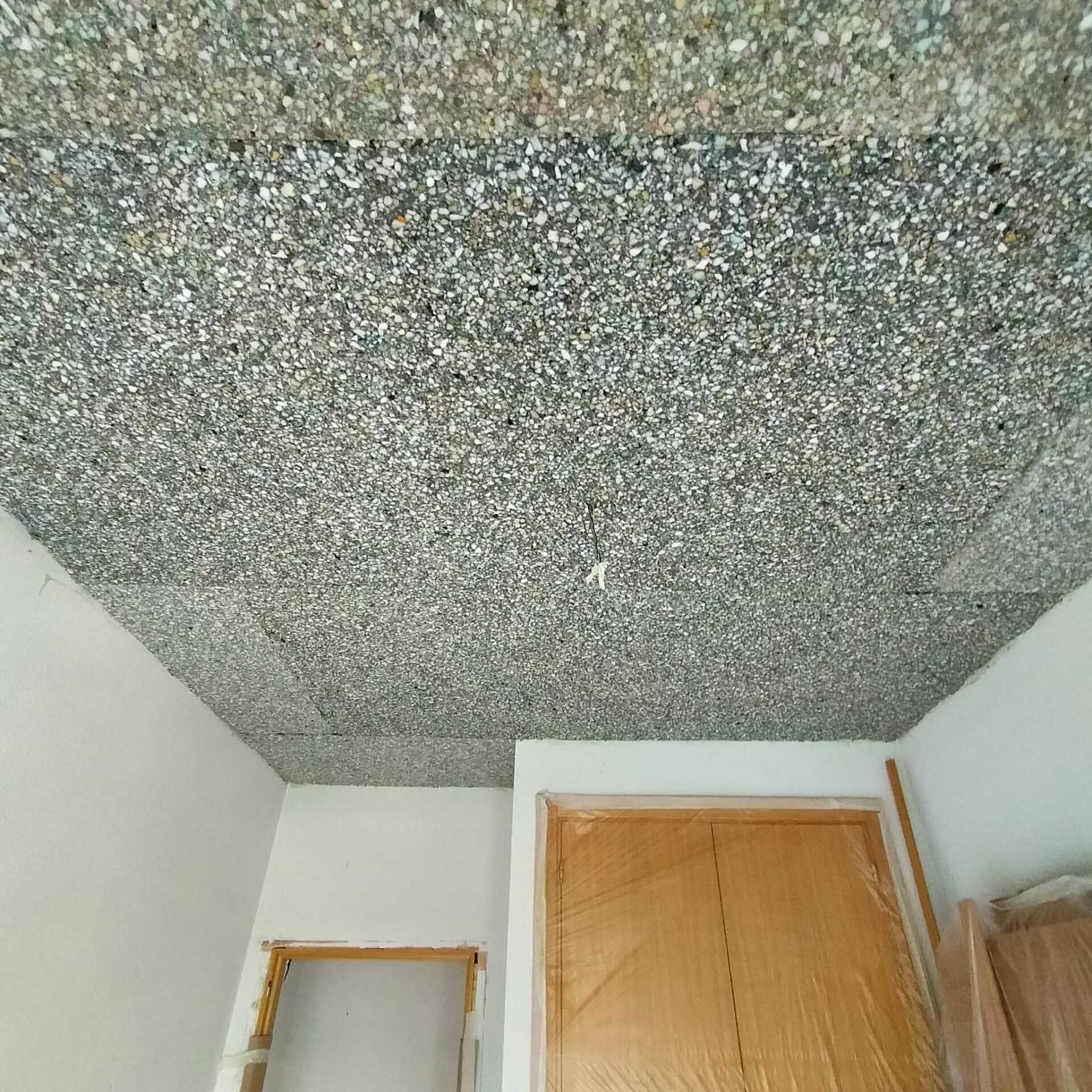 Una habitación con techo gris y puerta de madera.