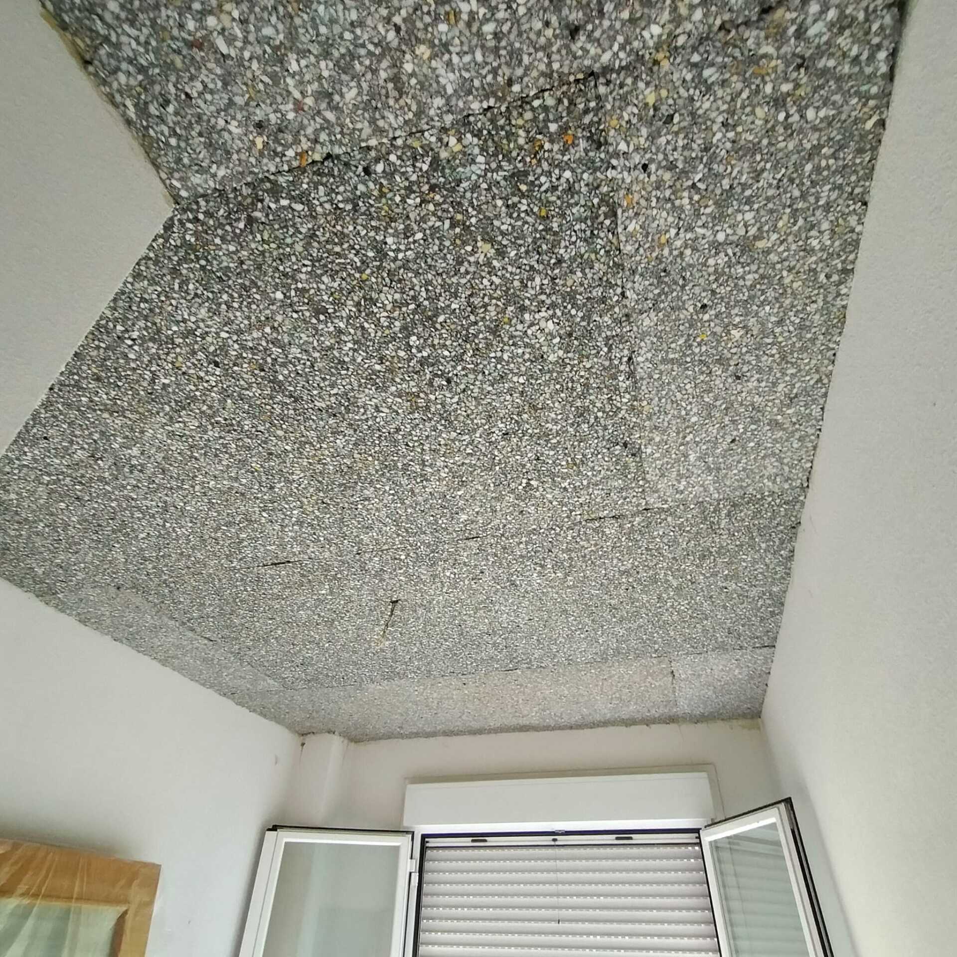 Una habitación con techo y ventana con contraventanas.