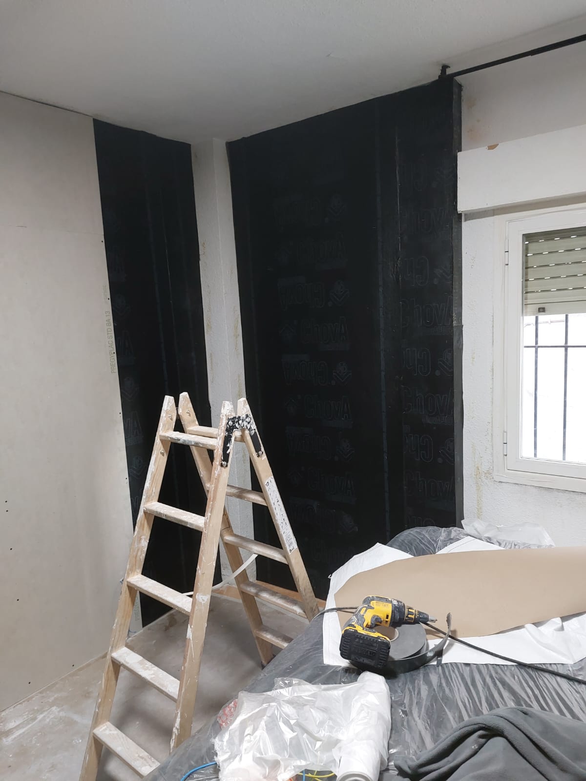 Hay una escalera de madera en una habitación junto a una ventana.