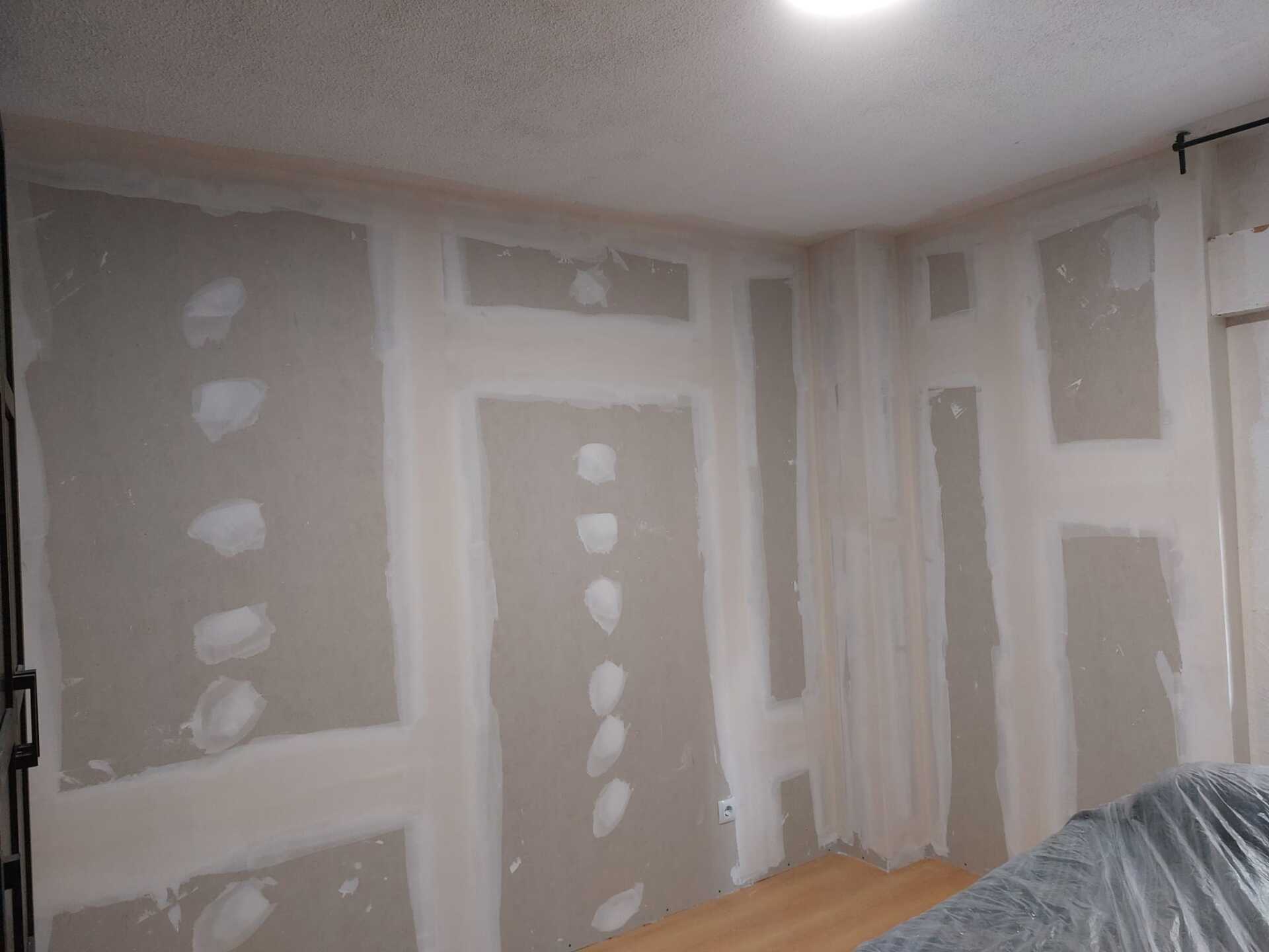Una habitación con paredes de yeso y piso de madera.