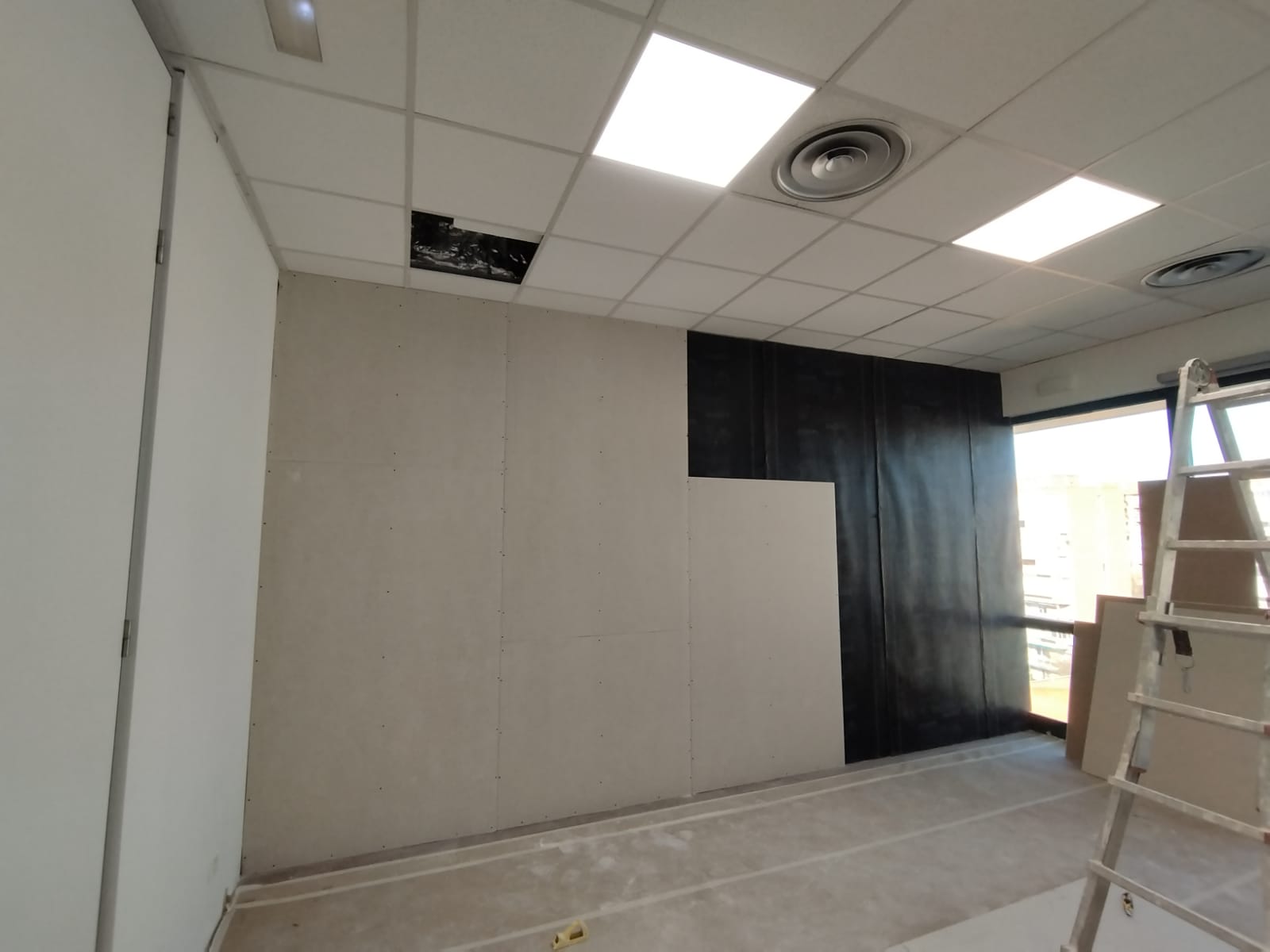 Una habitación con escalera y techo que está siendo remodelada.