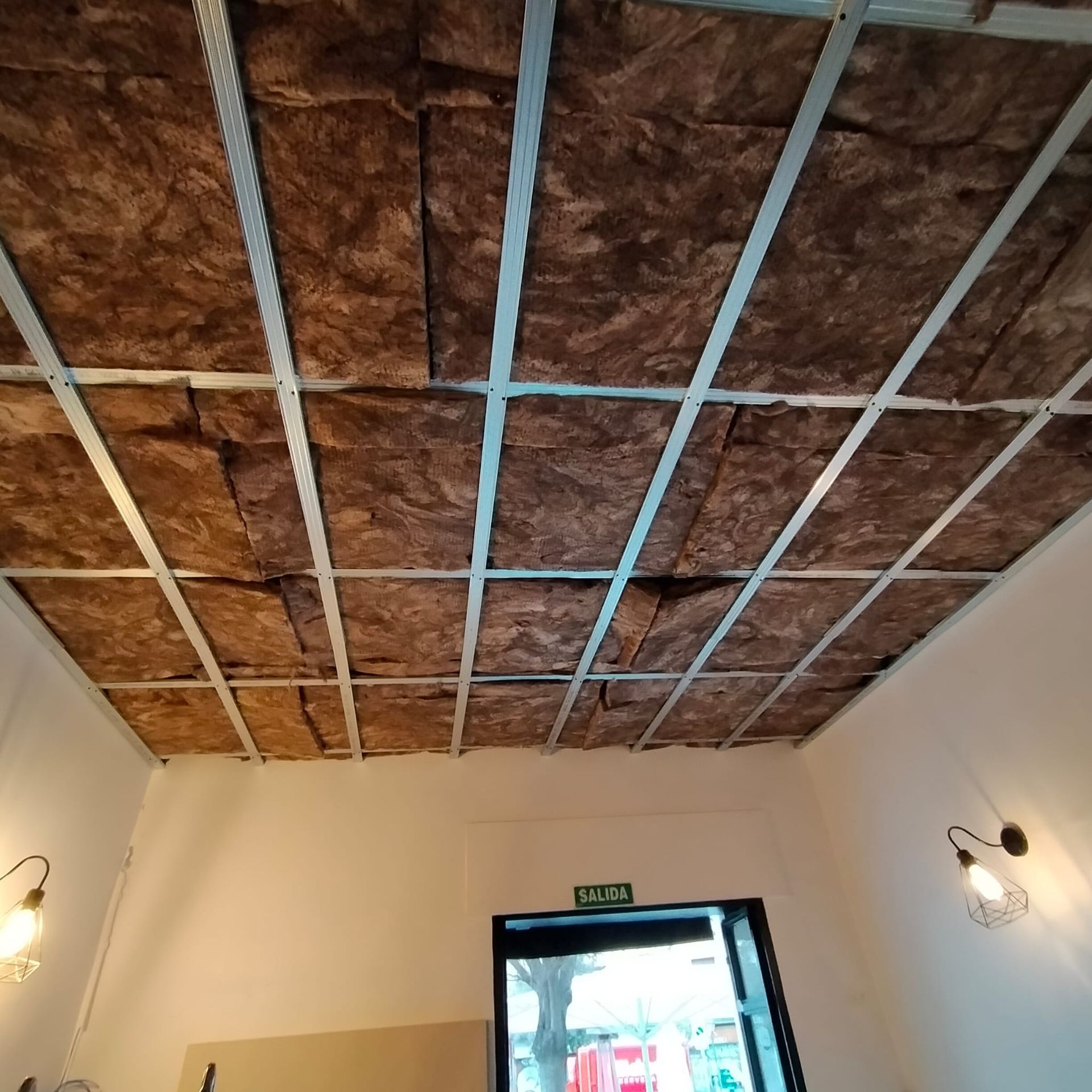 Una habitación con una señal de salida verde en la pared