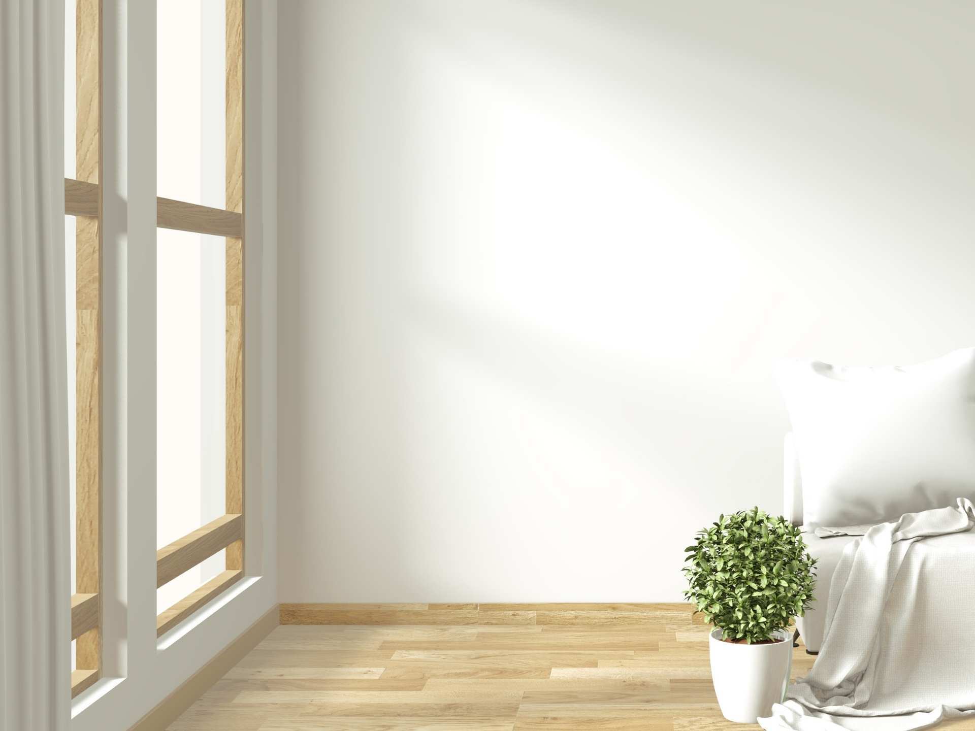 Una habitación vacía con una cama, una maceta y una ventana.