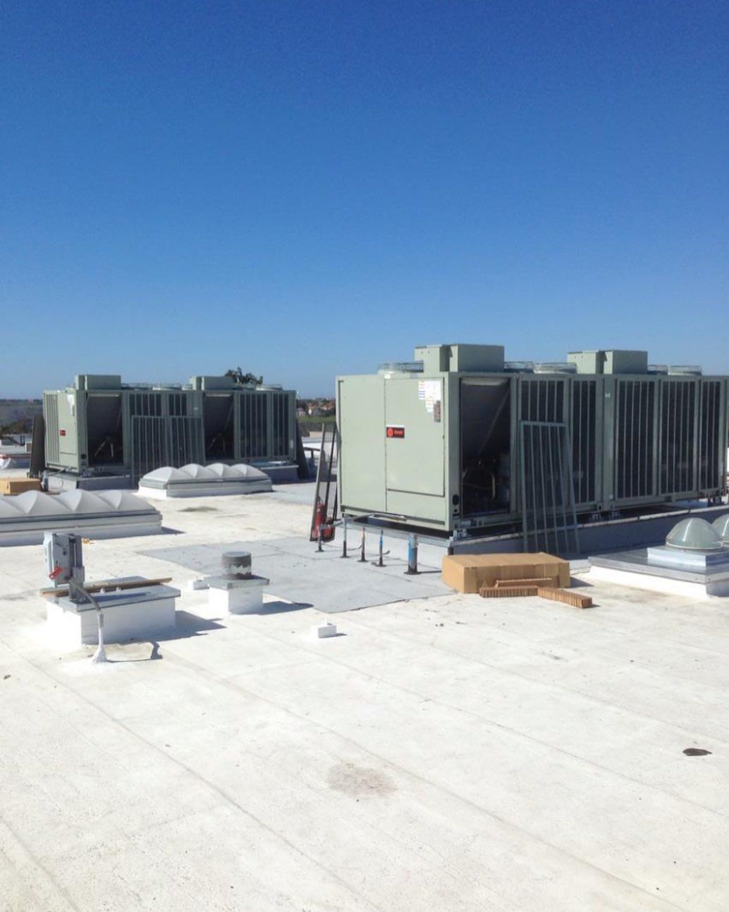 A white roof with a lot of air conditioners on it