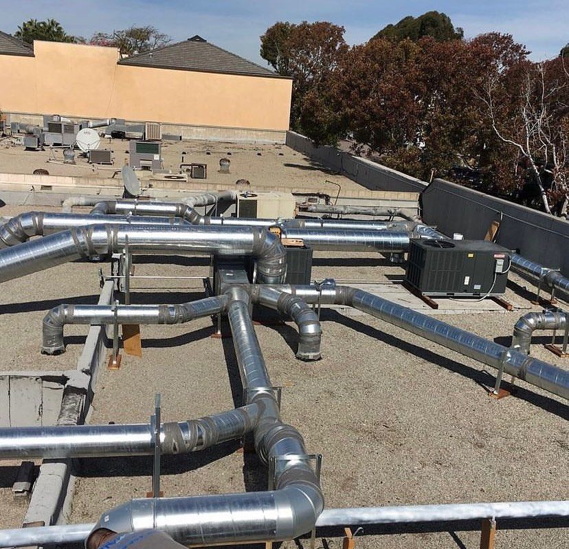 A bunch of metal pipes on the roof of a building