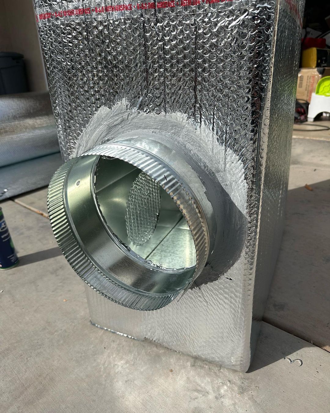 A metal pipe with a hole in the middle is sitting on the ground.