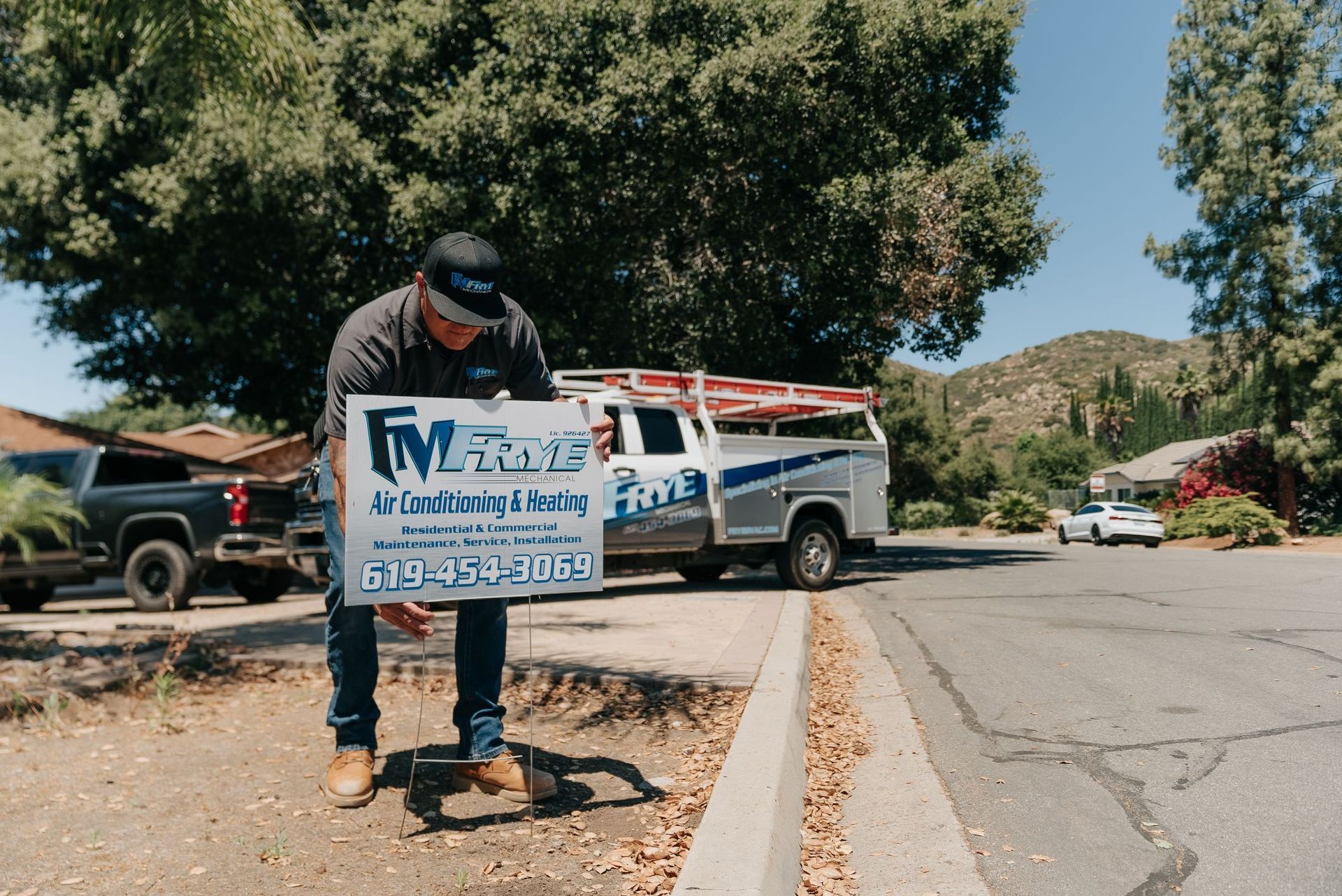A man is holding a sign in front of a truck.