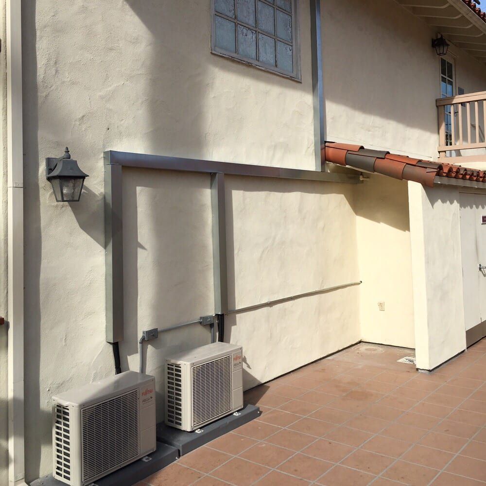Two air conditioners on the side of a building