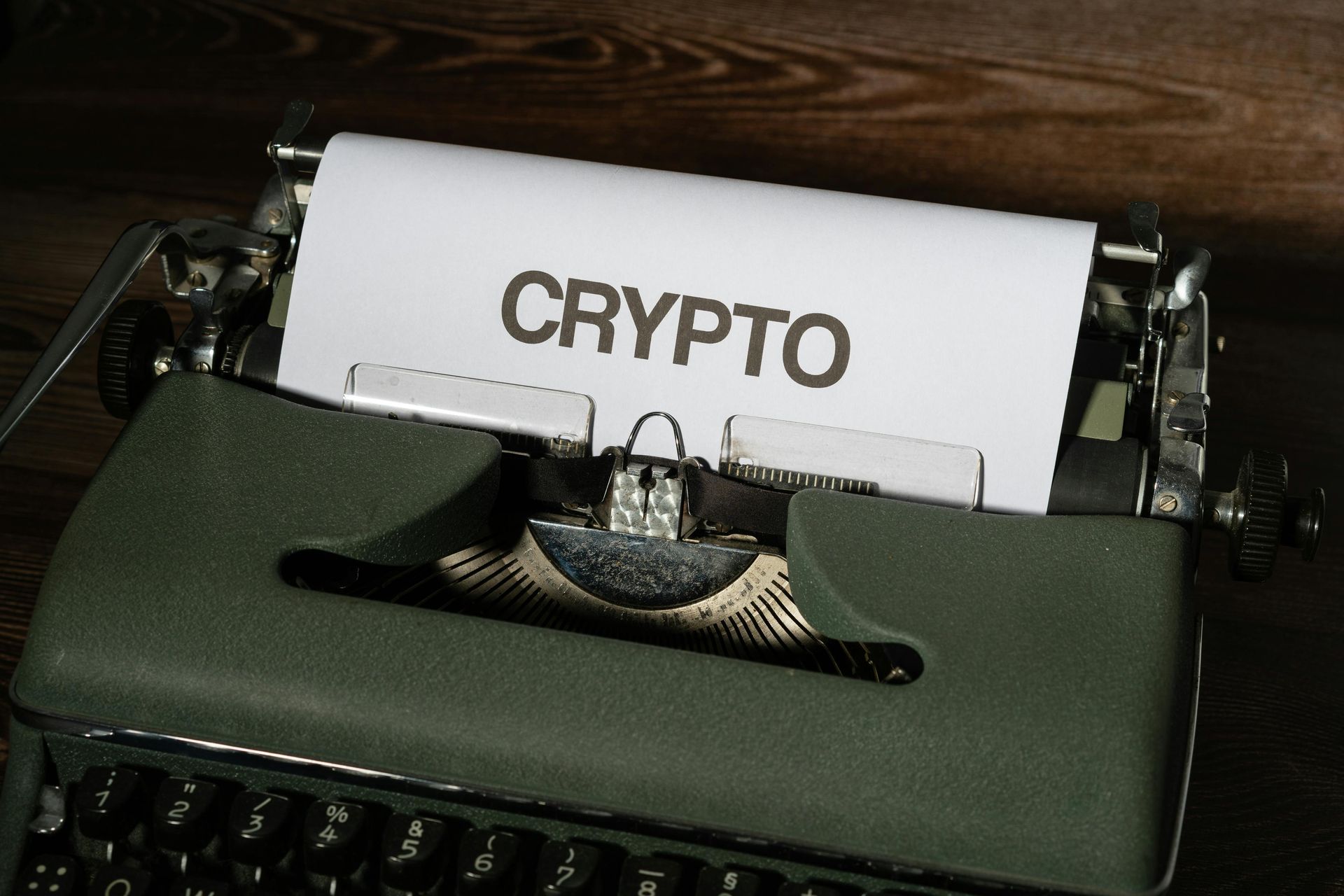 Typewriter with a paper labeled “CRYPTO” on a dark wooden desk