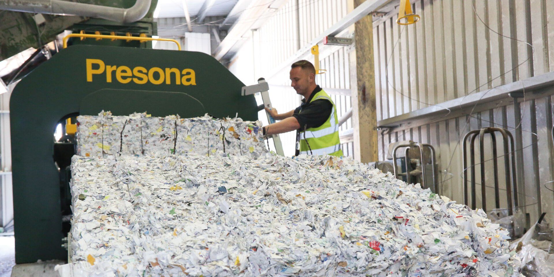 A man is standing in front of a pile of shredded paper.