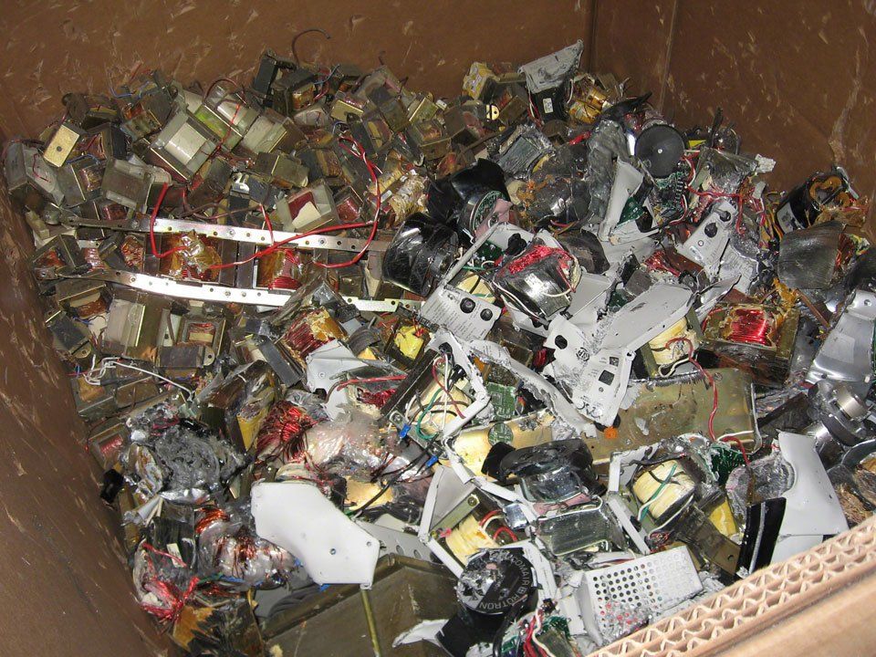 A pile of electronics in a cardboard box
