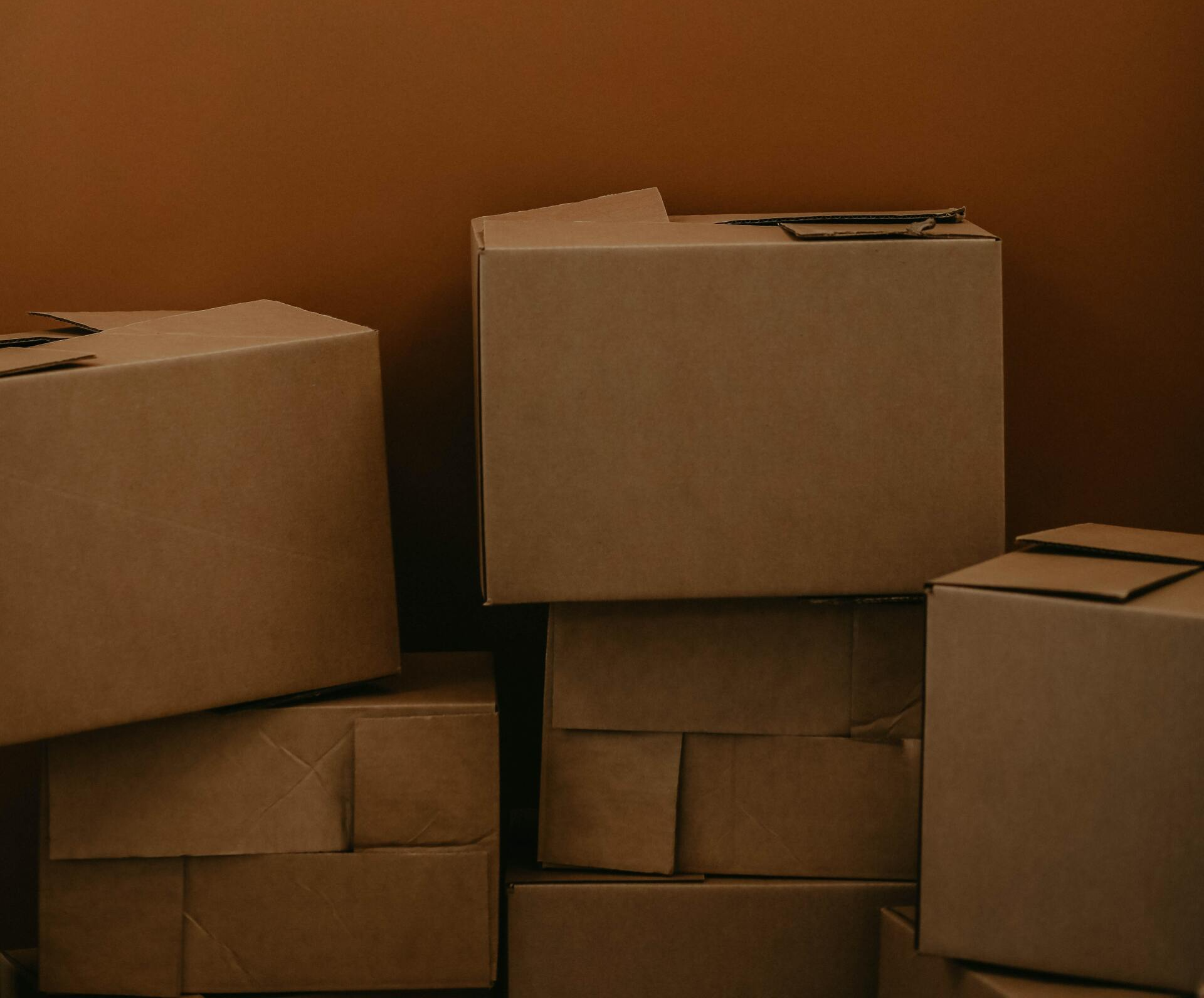 A pile of cardboard boxes stacked on top of each other in a room.