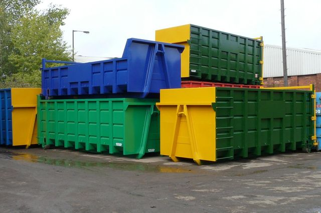 A bunch of colorful dumpsters are stacked on top of each other