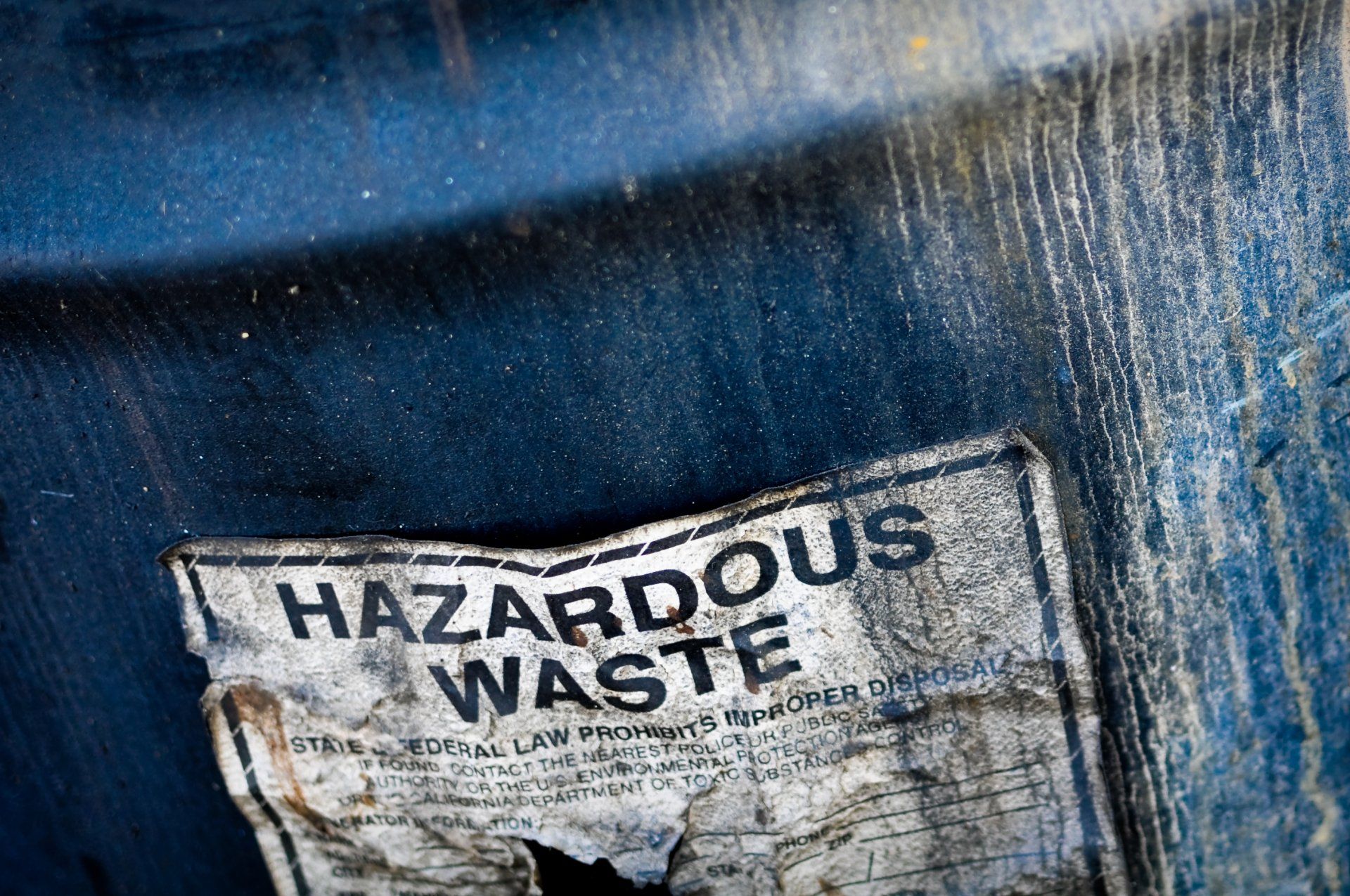 A blue barrel with a hazardous waste sign on it