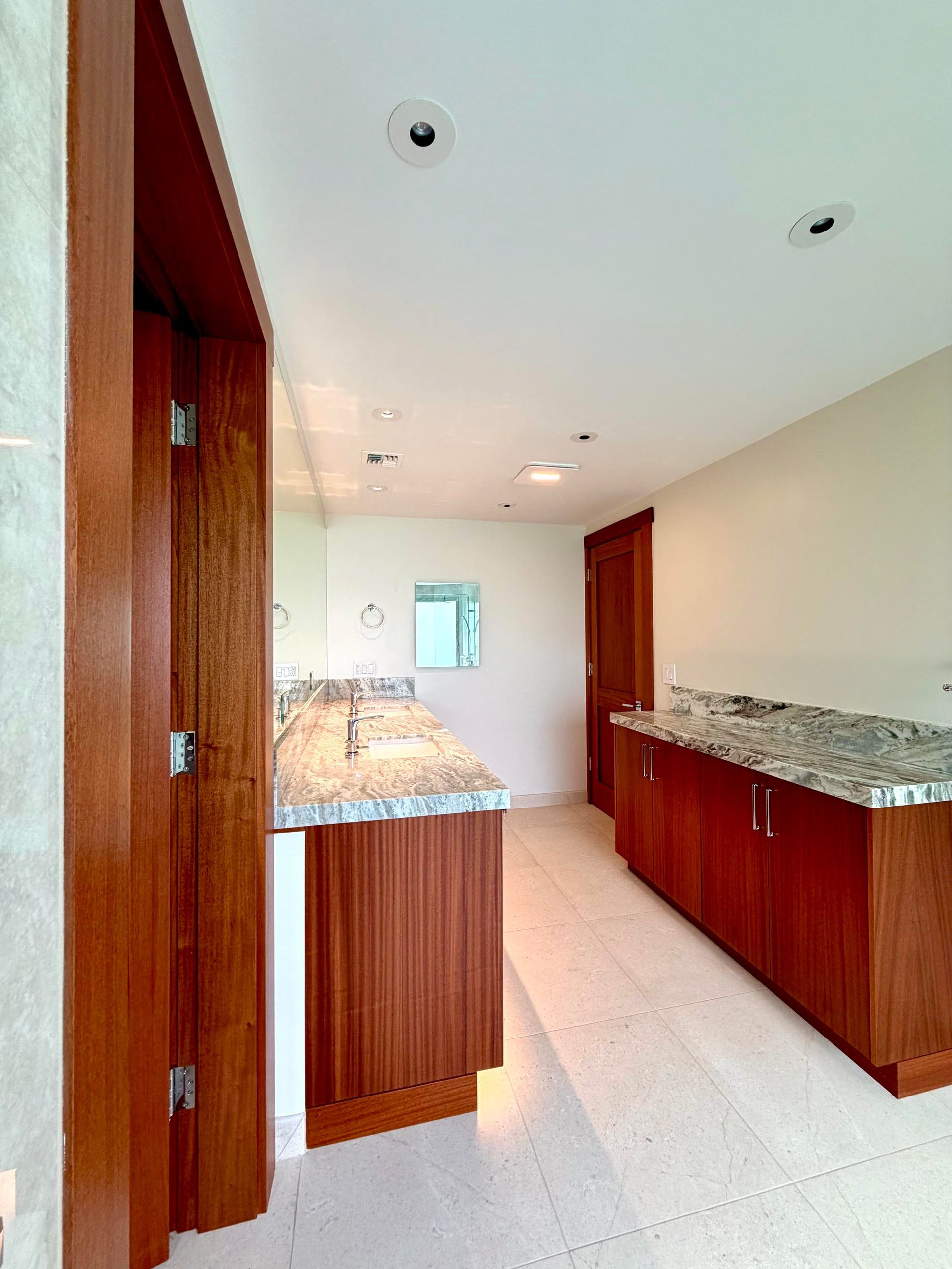 Bright modern kitchen with granite countertops, wood cabinets, and white tile floor