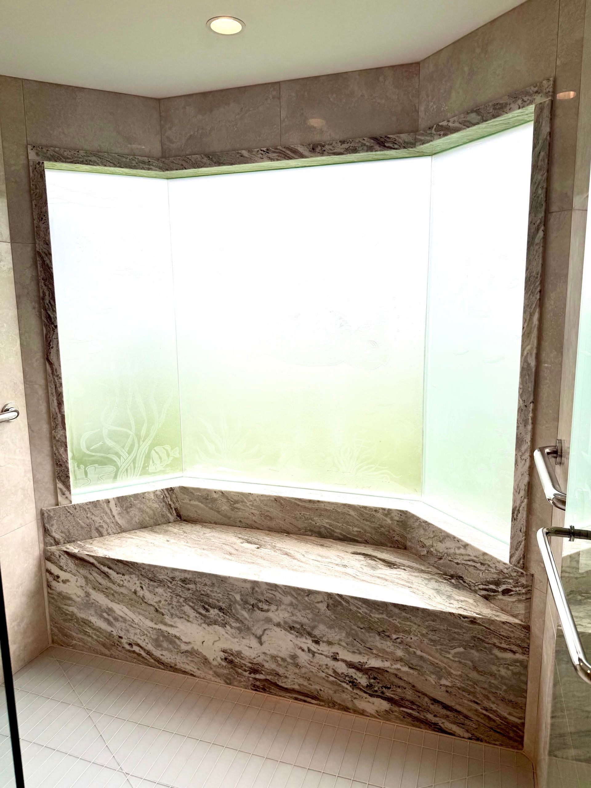 Curved stone window seat beneath frosted windows in a bright bathroom corner