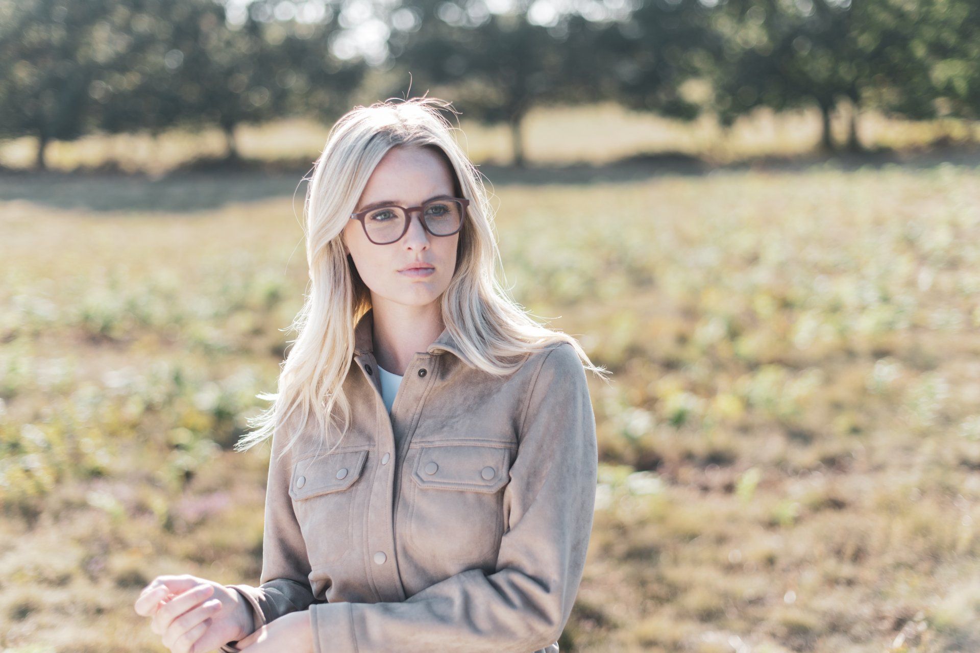 person in field wearing glasses