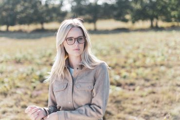 person in field wearing glasses