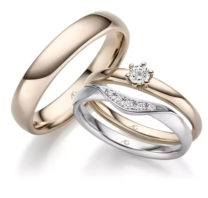Drie trouwringen: één gouden ring, één gouden ring met een diamant en één zilveren ring met diamanten.