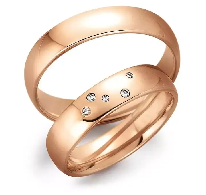 Trouwringen van roségoud, waarvan één met vijf kleine diamanten.
