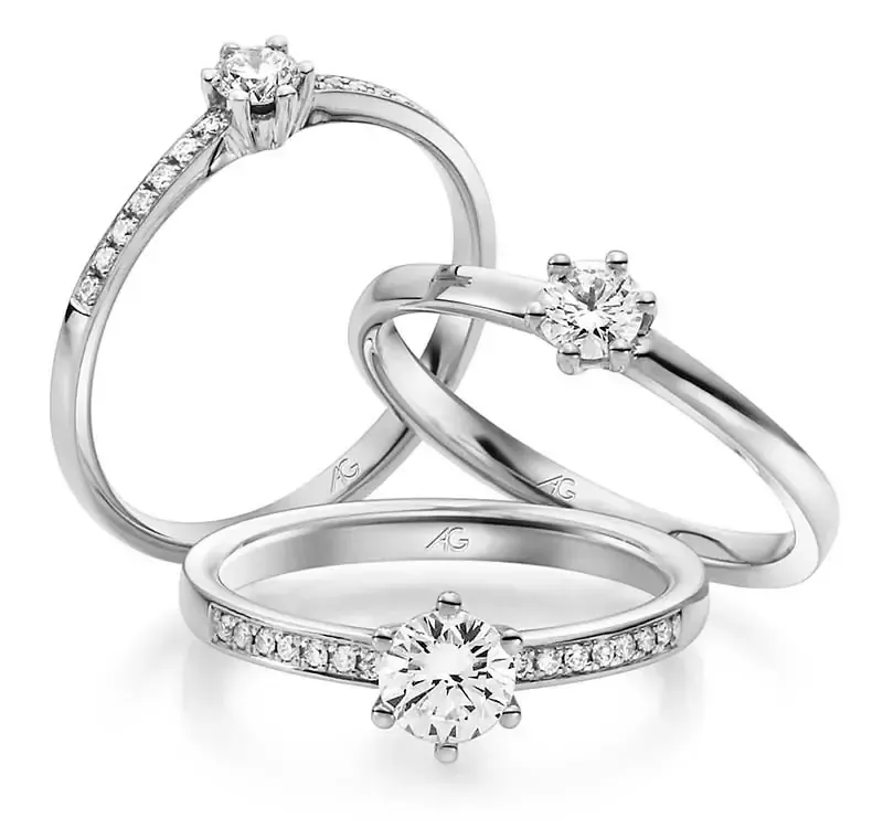 Drie verlovingsringen met diamanten: twee solitairen en één met pavé diamanten, allemaal van zilver.