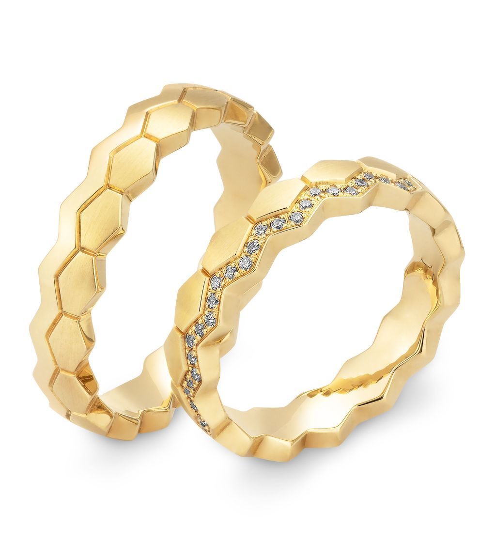 Twee gouden trouwringen met honingraatmotief, waarvan één met kleine diamanten.
