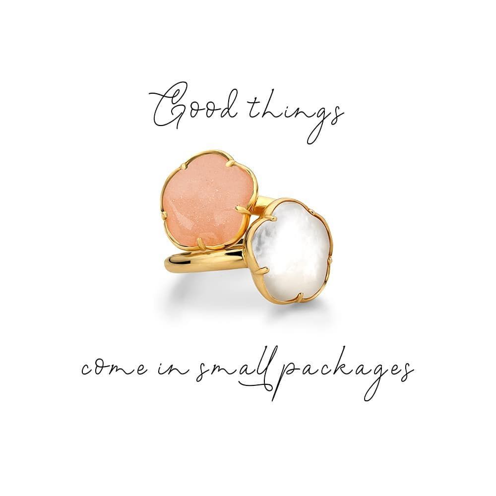 Gouden ring met twee bloemvormige stenen: een roze en een witte. De tekst luidt: