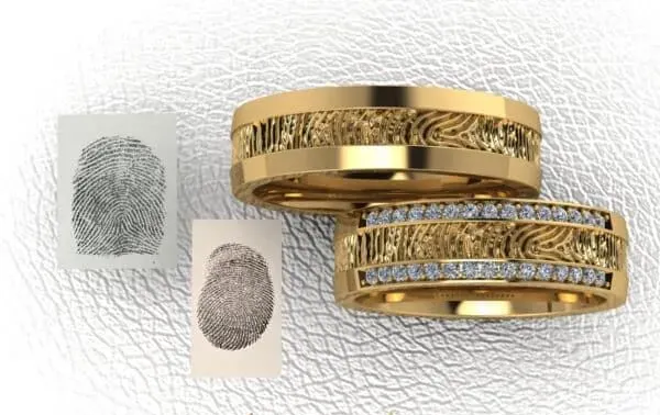 Twee gouden trouwringen met vingerafdruktextuur.