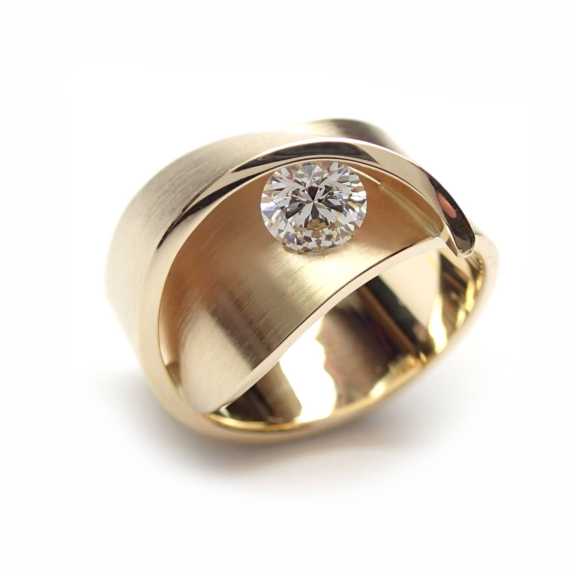 Gouden ring met een centrale diamant, uniek sculpturaal ontwerp.