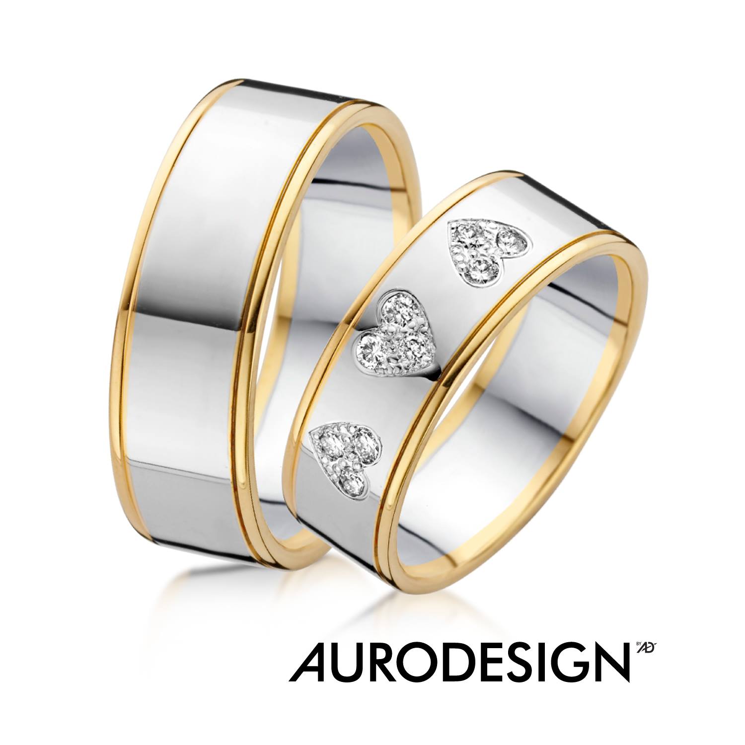 Tweekleurige trouwringen: zilveren band met gouden randen. Eén ring heeft een diamanthartmotief.