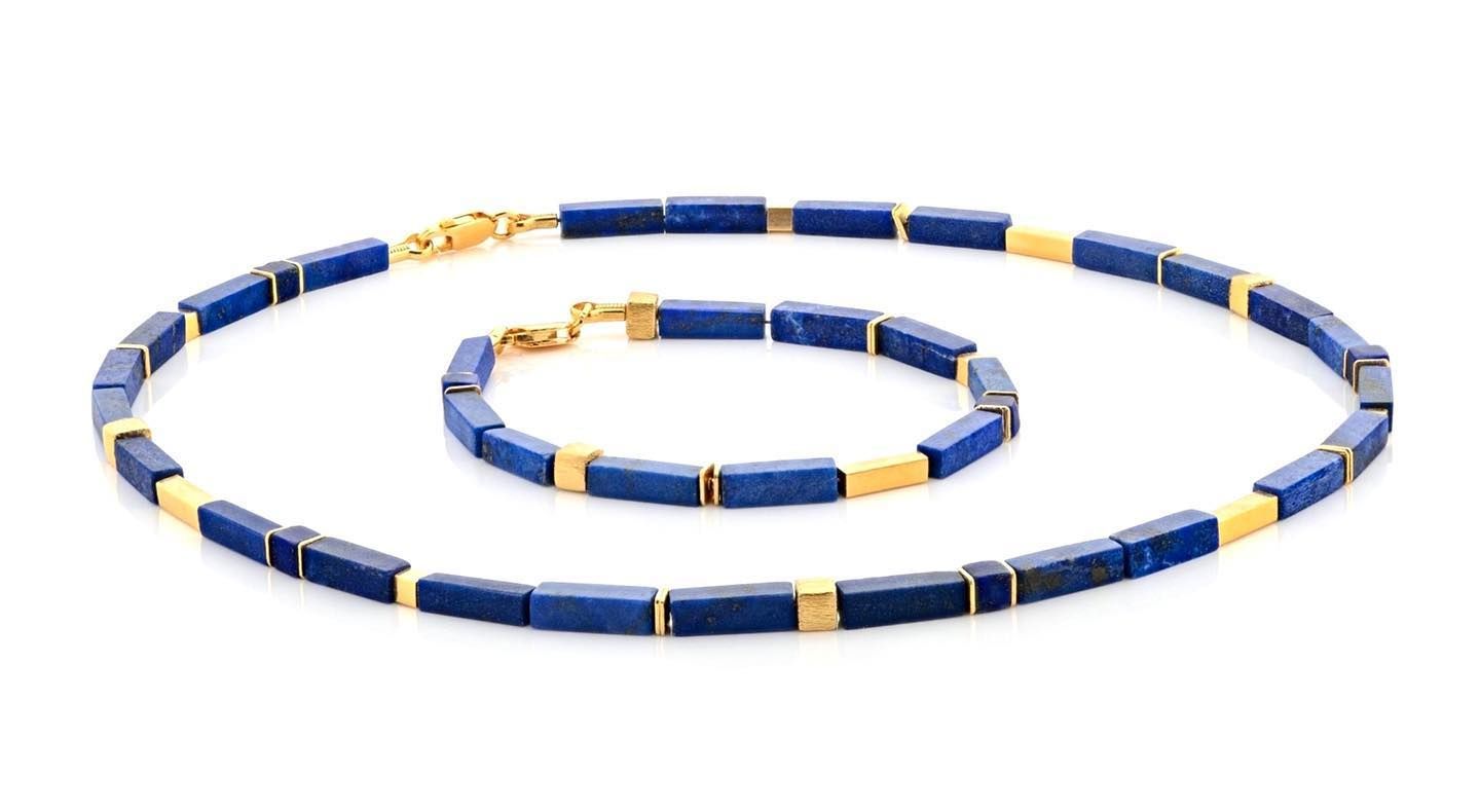 Ketting en armband van blauw lapis lazuli en goud op een wit oppervlak.