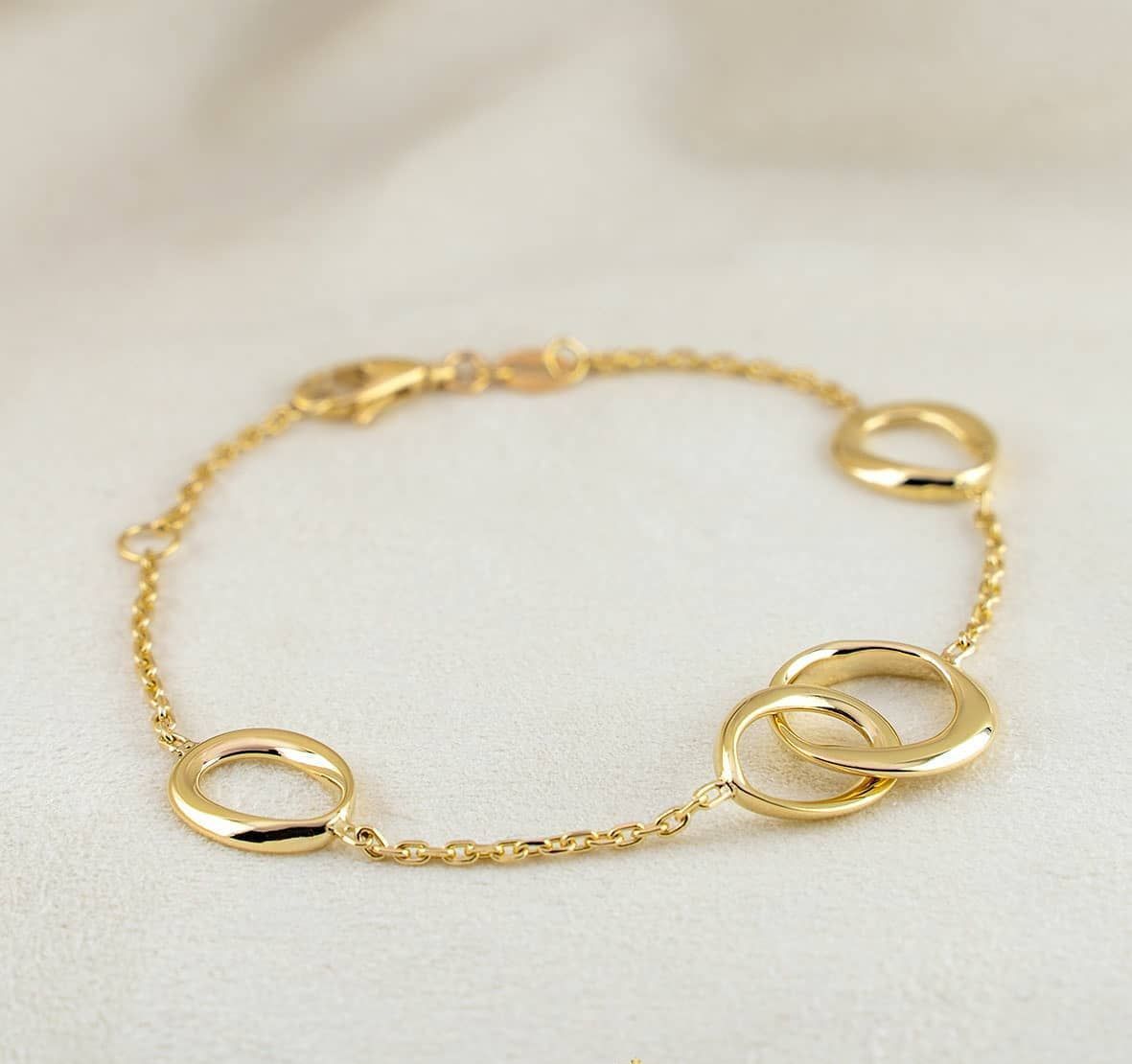Gouden armband met in elkaar grijpende ringen en schakels.