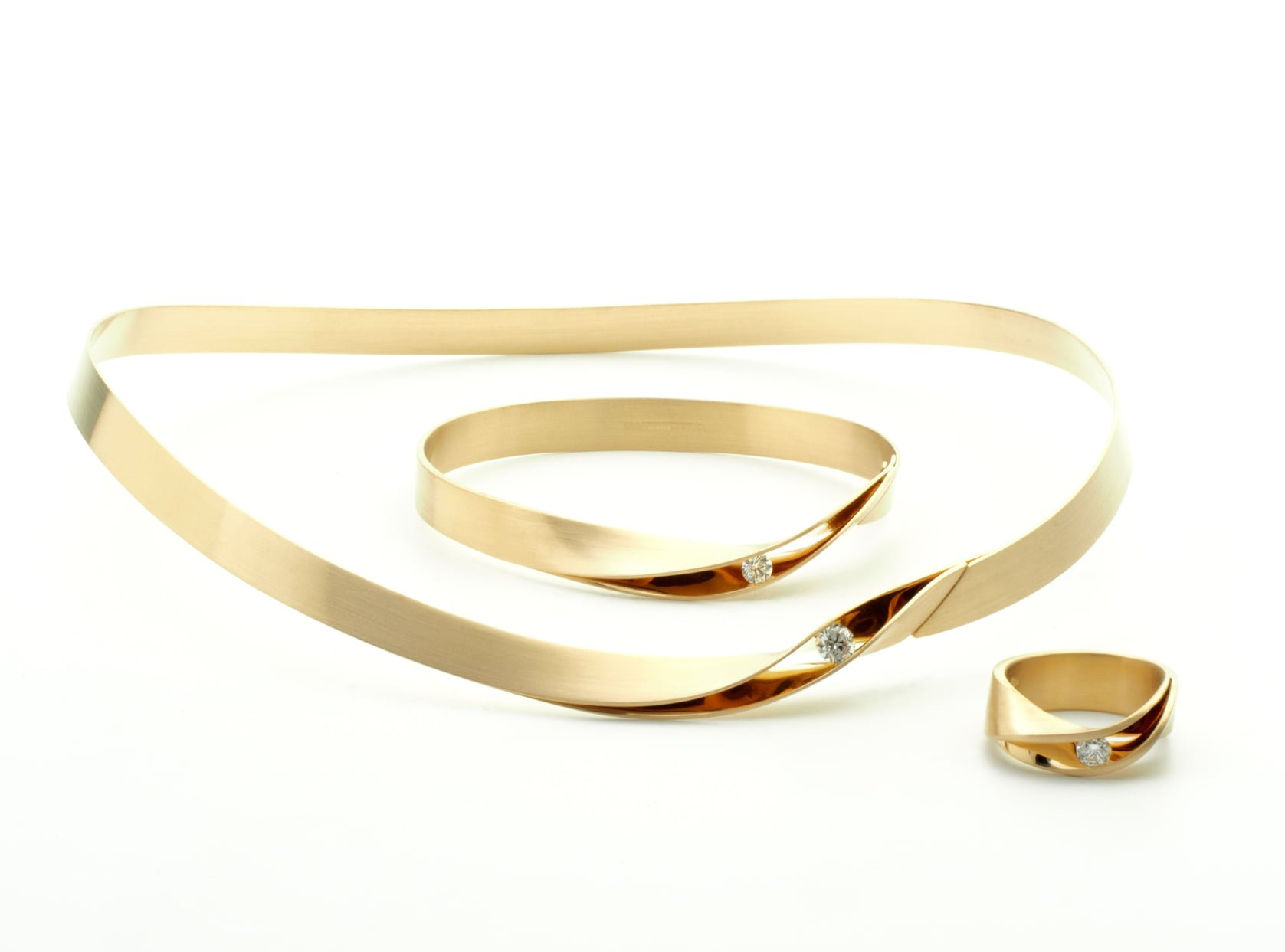 Gouden sieradenset: ketting, armband en ring, allemaal met een gedraaid ontwerp en kleine diamantaccenten.