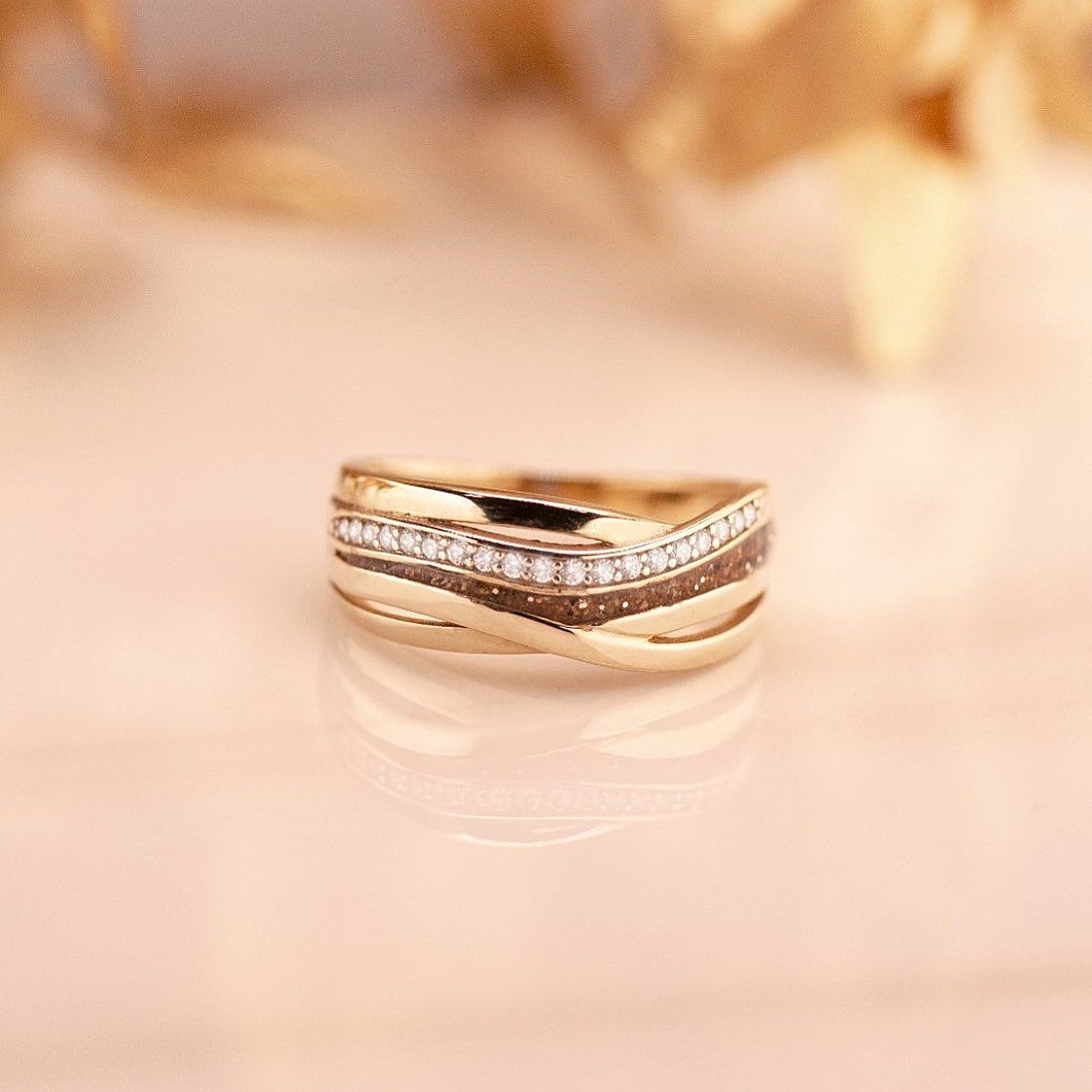 Gouden ring met golfmotief, bezet met kleine diamantjes.
