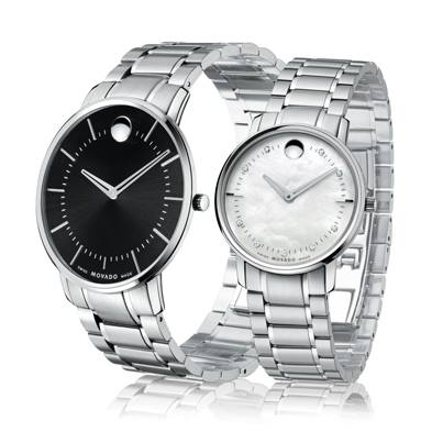 Twee Movado horloges: één met een zwarte wijzerplaat, de ander met een witte wijzerplaat; beide met zilveren bandjes.