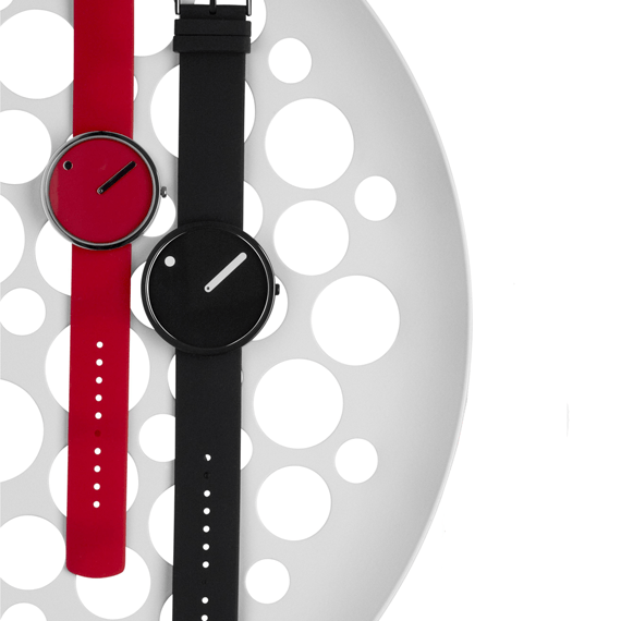 Minimalistische horloges in de kleuren rood en zwart op een witte gestippelde achtergrond.