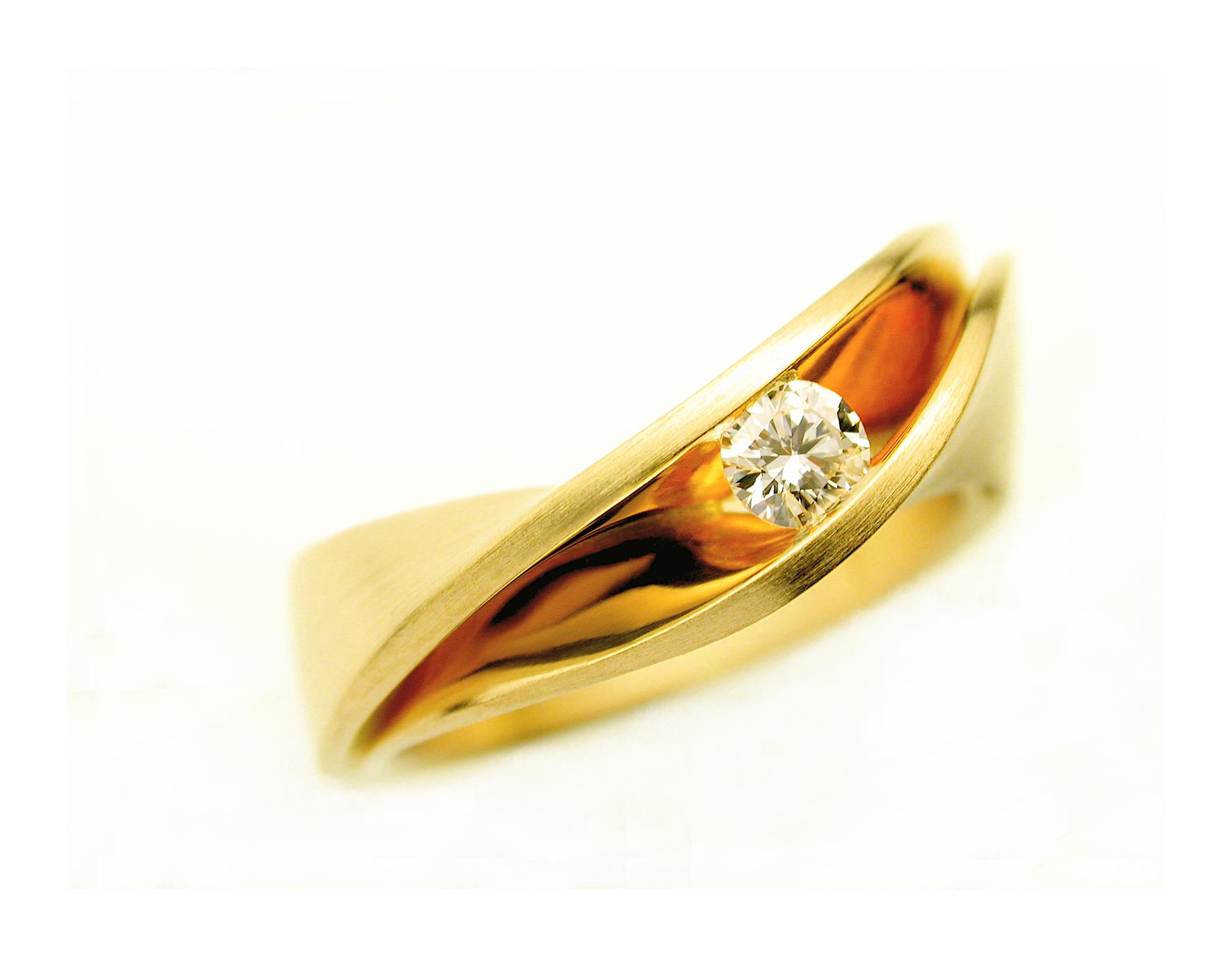 Gouden ring met diamant gezet in een gebogen kanaal, tegen een witte achtergrond.