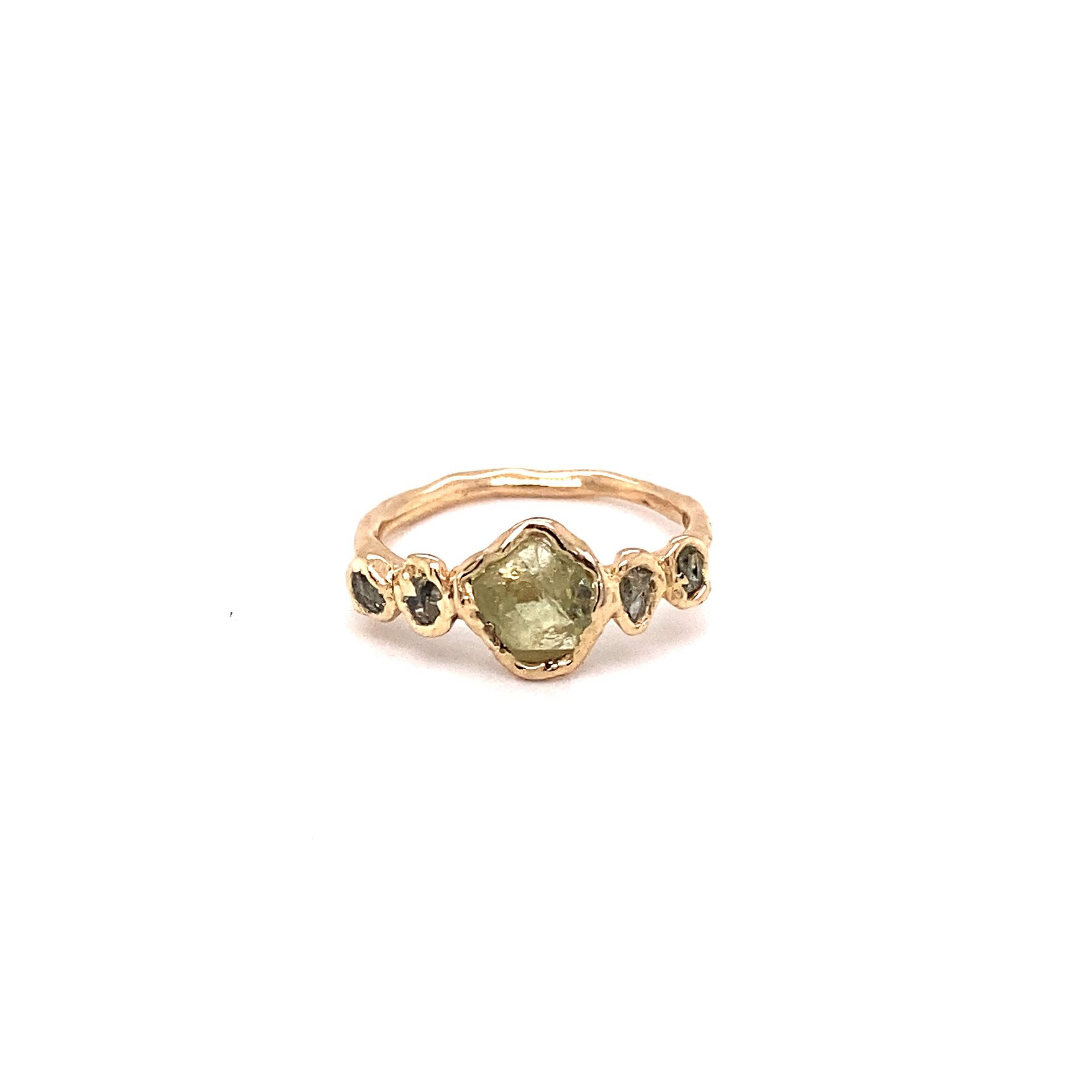 Gouden ring met groene en donkergrijze edelstenen.
