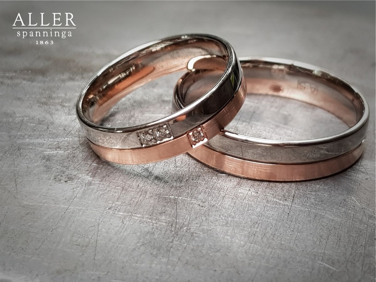 Twee trouwringen; zilveren ringen met roségouden centra, één met kleine diamanten.