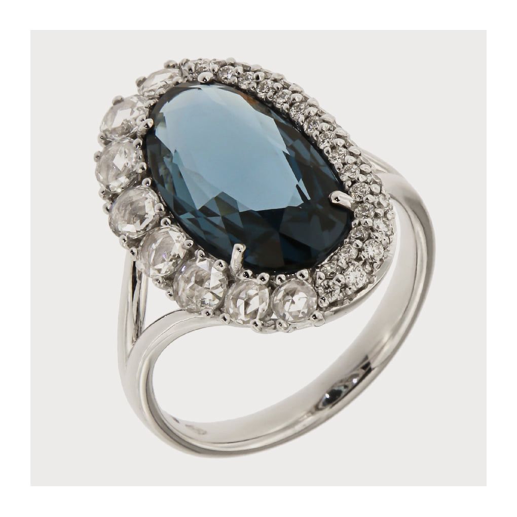 Zilveren ring met een grote, blauwe, ovale edelsteen, omringd door kleinere, witte edelstenen.