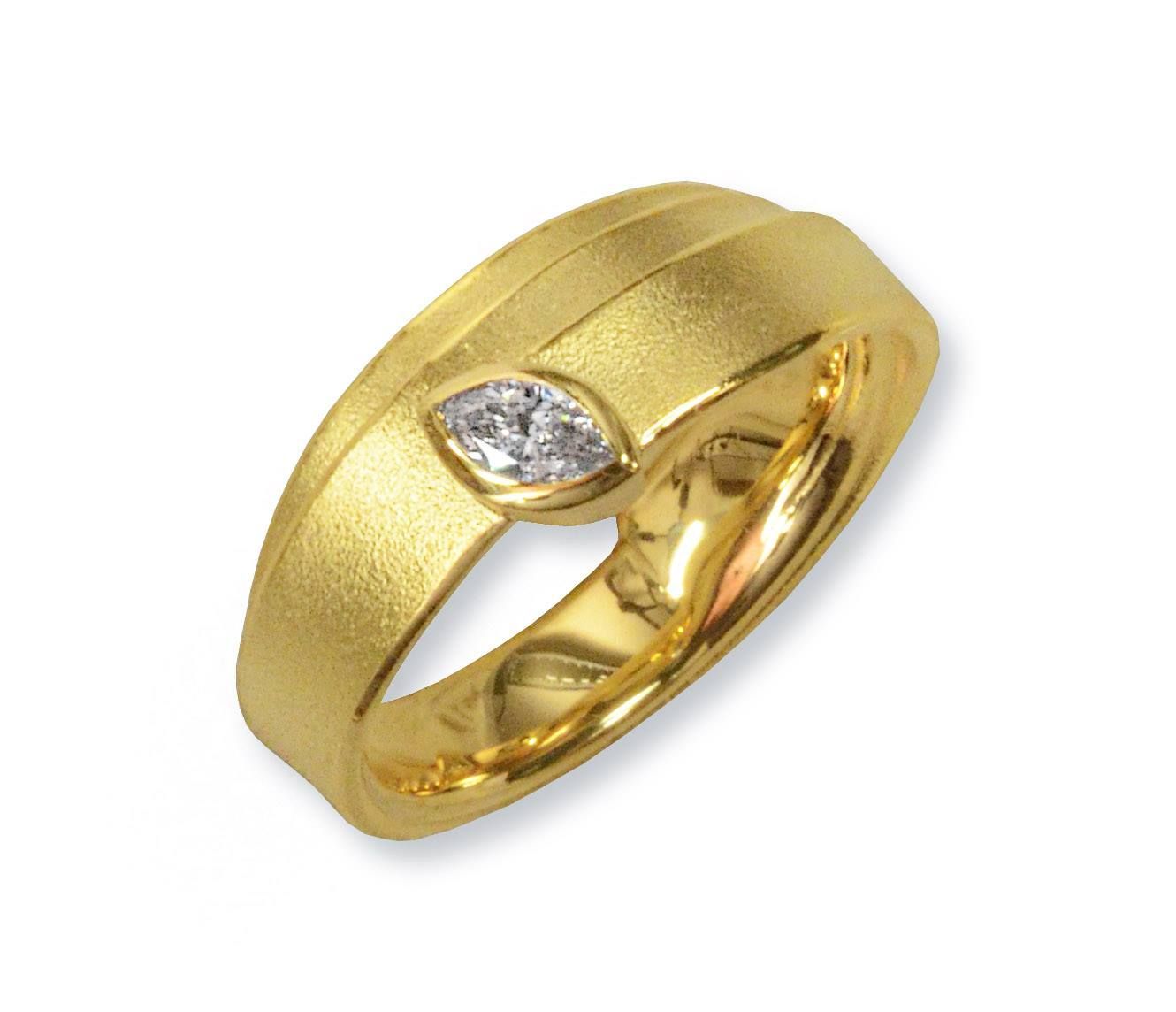 Gouden ring met een marquise geslepen diamant op een gestructureerde band.